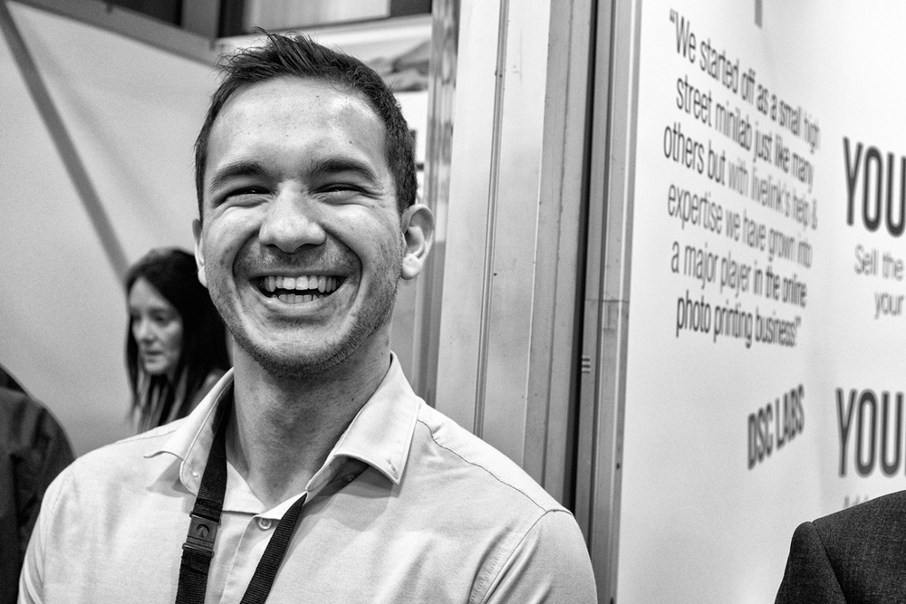 Exhibitors do seem happy to see their visitors (Fuji X100S, ISO 1600)