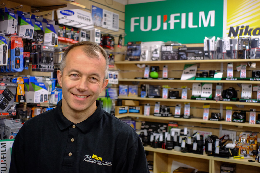 Andy at Chiswick Camera Centre. Above, Fuji X-T1 with Leica 28mm f/2.8 Elmarit. Below, Same camera, this time with the Fujinon f/2.8 27mm pancake. Both shots at f/2.8 and 1/125s, full-frame equivalent of 41mm.
