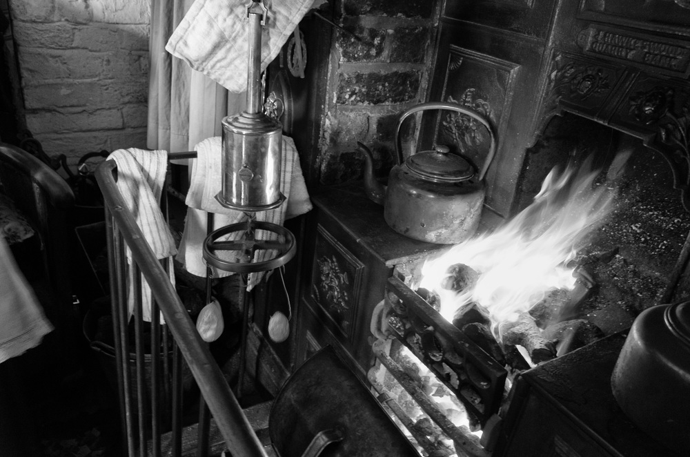 Cottage dwellers cooking their lunch over the fire--note the two forlorn spuds dangling from the patent clockwork roasting spit (Ricoh GR)