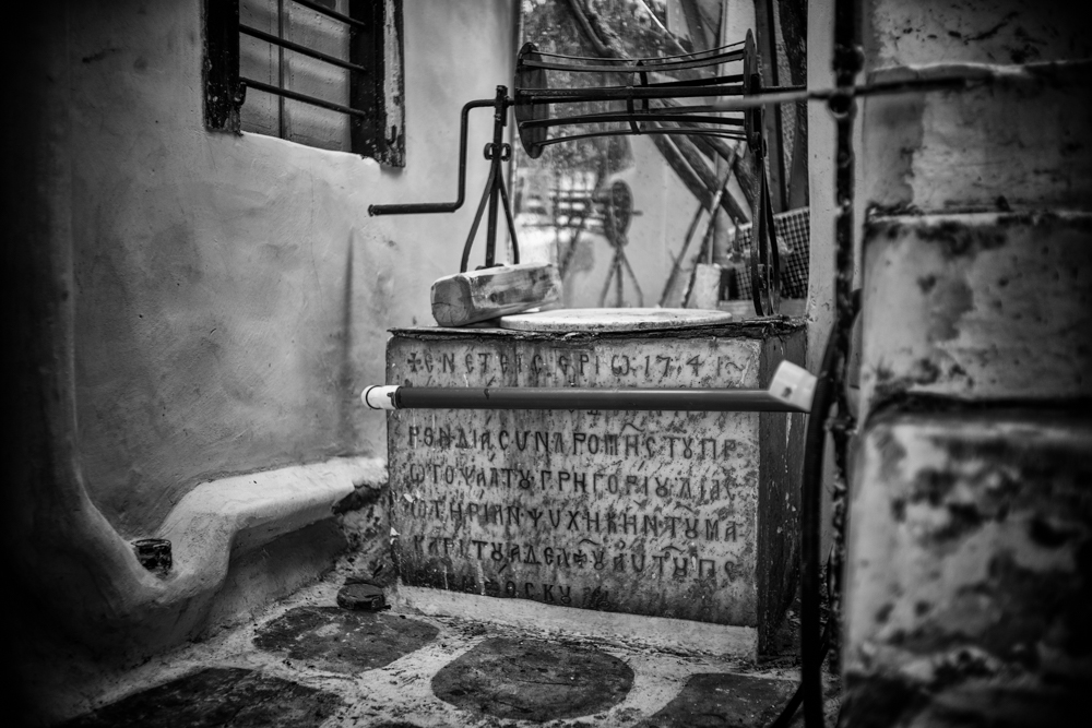   Above: This well in the main street, Matogianni, now finds itself inside a restaurant under refurbishment. Built in 1741, it has a voluble inscription in Byzantine Greek which was well beyond my modest capabilities. In the centre, though, I did focus on the most apposite word   Ψ  ΥΧΗ   (psyche). This old well truly does represent the soul of Mykonos. (Sony/Leica)  