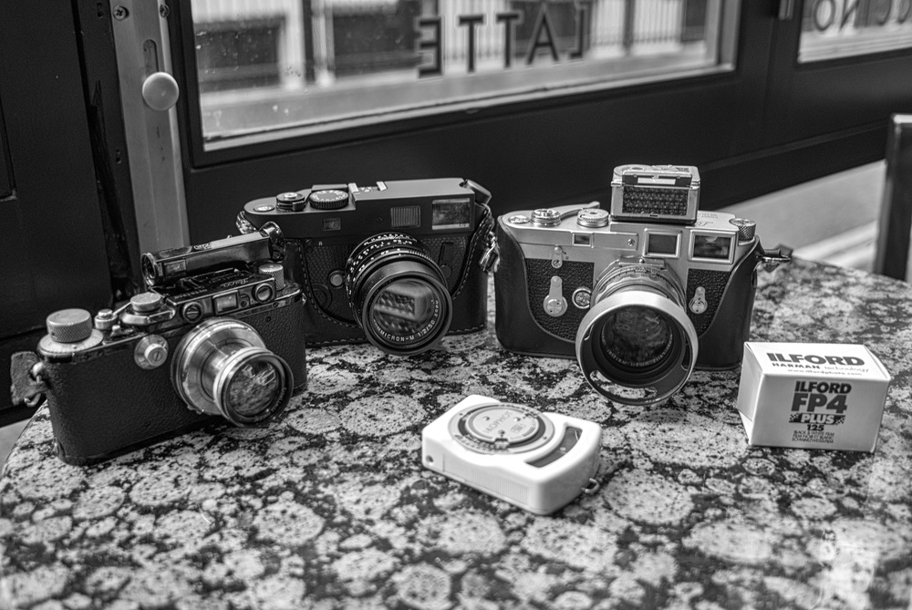 On the starting grid: Three film cameras, one roll of film and two rather mad camera nerds. Left to right: Leica III and 5cm Summar, plus Winkelsucher (1936); Neil the M7 (2004) and 50mm Apo-Summicron; Leica M3 double-stroke (1957) with 50mm Summicron dual-range (with Sekonic light meter on top), Ilford FP4 and Adam