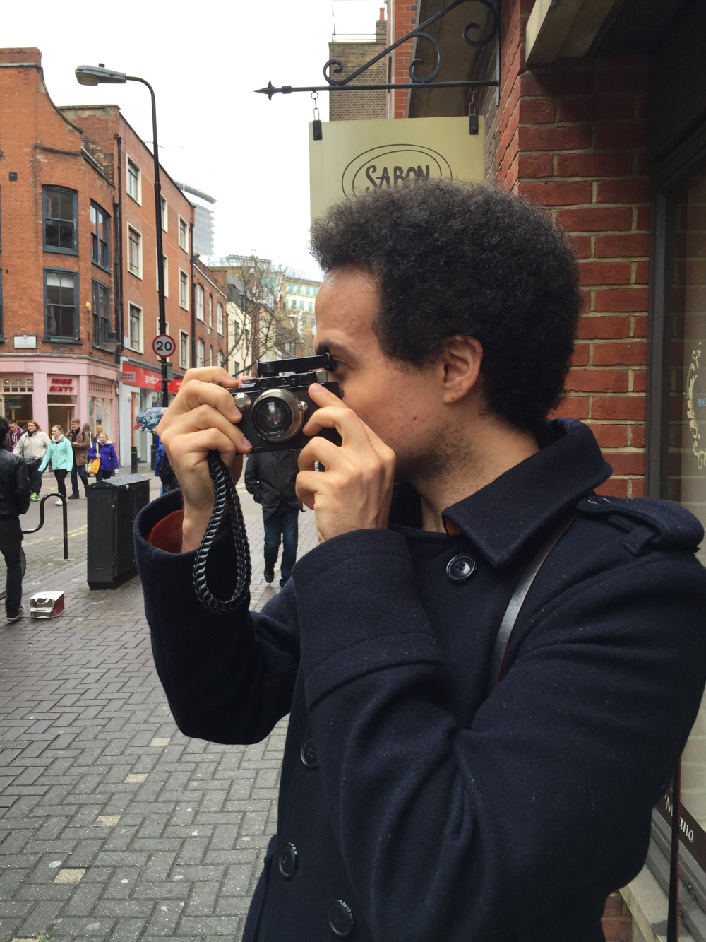 Adam takes a picture of me wielding the iPhone using the Leica