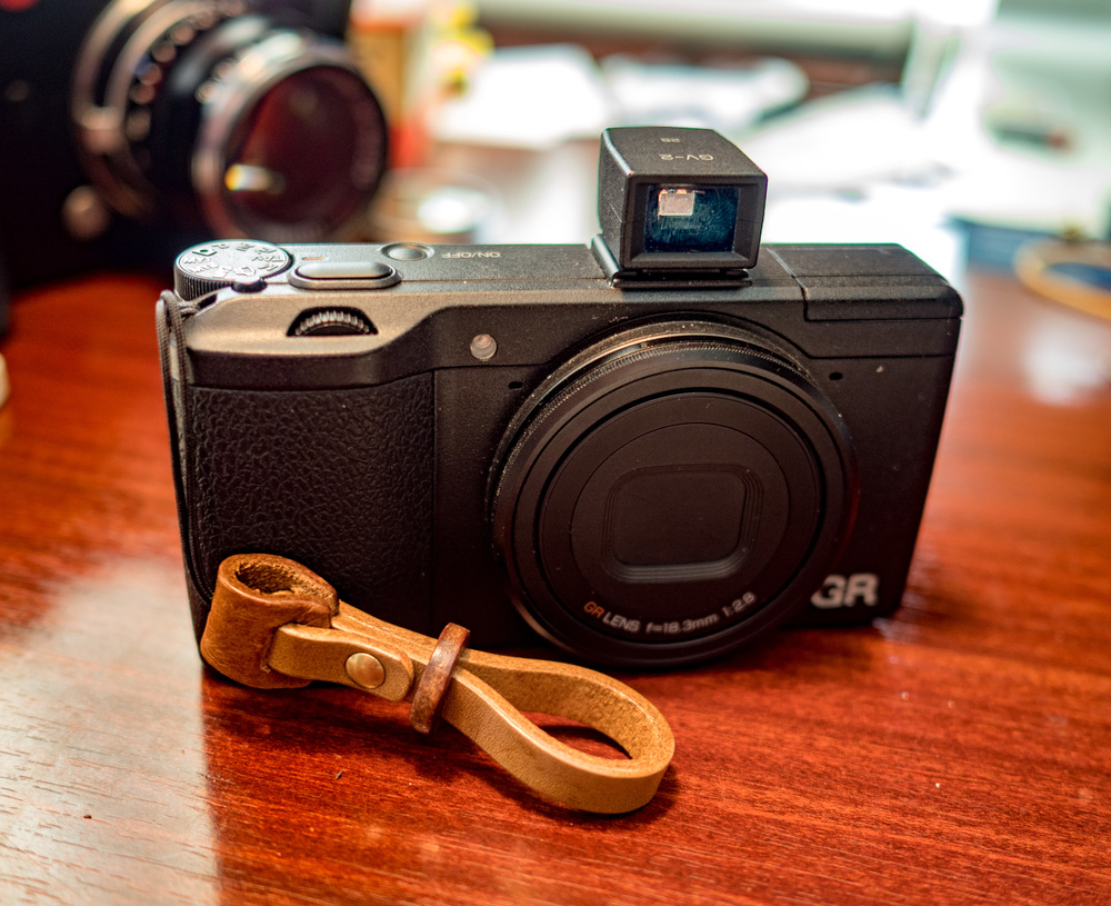 My new Ciesta strap on the GR. As with all accessory straps, a string loop is used to fix straps to the camera. But this works well with the little thumb strap, allowing sufficient leeway to use the camera comfortably