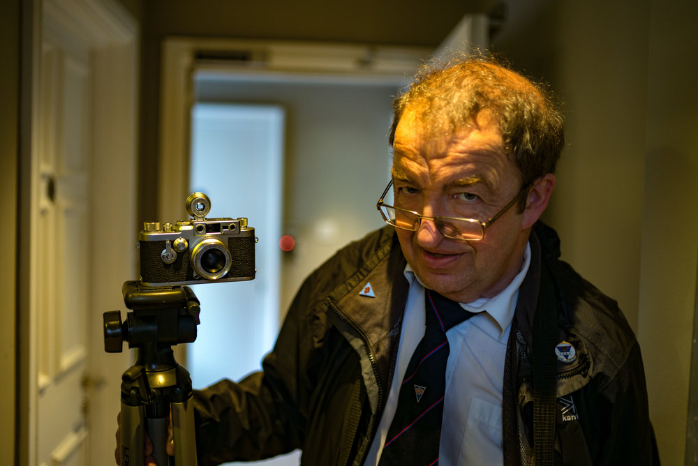 Vincent Roberts with his mint IIIg, the last of the screw-mount models in the tradition of the Barnack Leica. This camera was bought in 1957 by his father for £199. Vincent describes it as the finest camera ever made, pure mechanical perfection. Red dot in the bokeh obligingly provided by Leica. There
