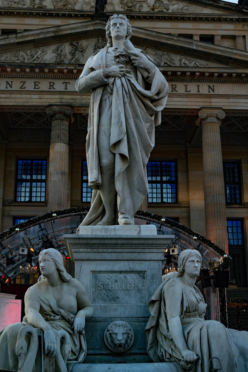 Friedrich Schiller, presiding over a joyous occasion with the Berlin Concert Hall in the background.