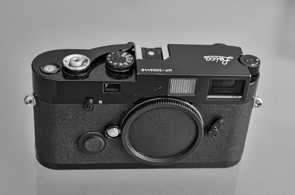   A modern black-paint MP film camera, this one manufactured in 2004 but still current in the catalogue. This is the more desirable MP, rather than the chrome version, and a similar model will sell for about £2,200. Even brassing, where the paint is rubbed   as a result of normal wear   to reveal the underlying brass (this camera has a little next to the strap lugs) will not be a problem since many collectors like it.   
