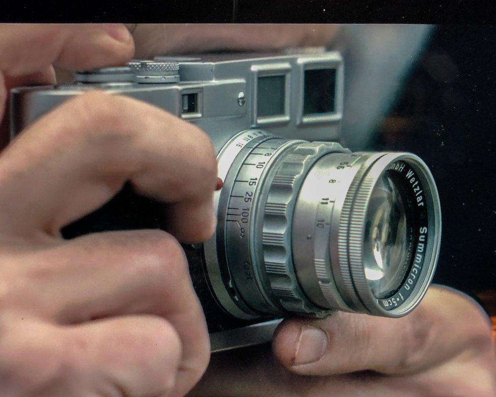 A screenshot from the opening sequence of episode four of the Netflix second series of The Crown. This camera and 5cm rigid Summicron is most definitely in period and I can
