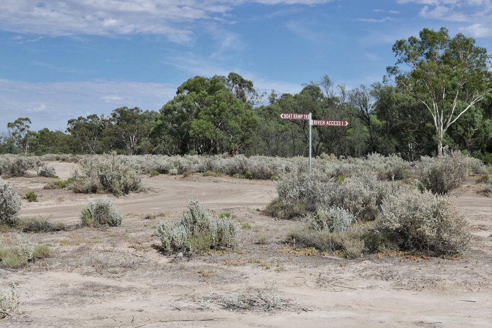   On shore, only saltbush and Eucalypts, and a single sign post breaks the monotony  