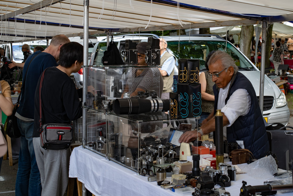 Setting up the stall — old and more recent cameras and lenses jockey for position.