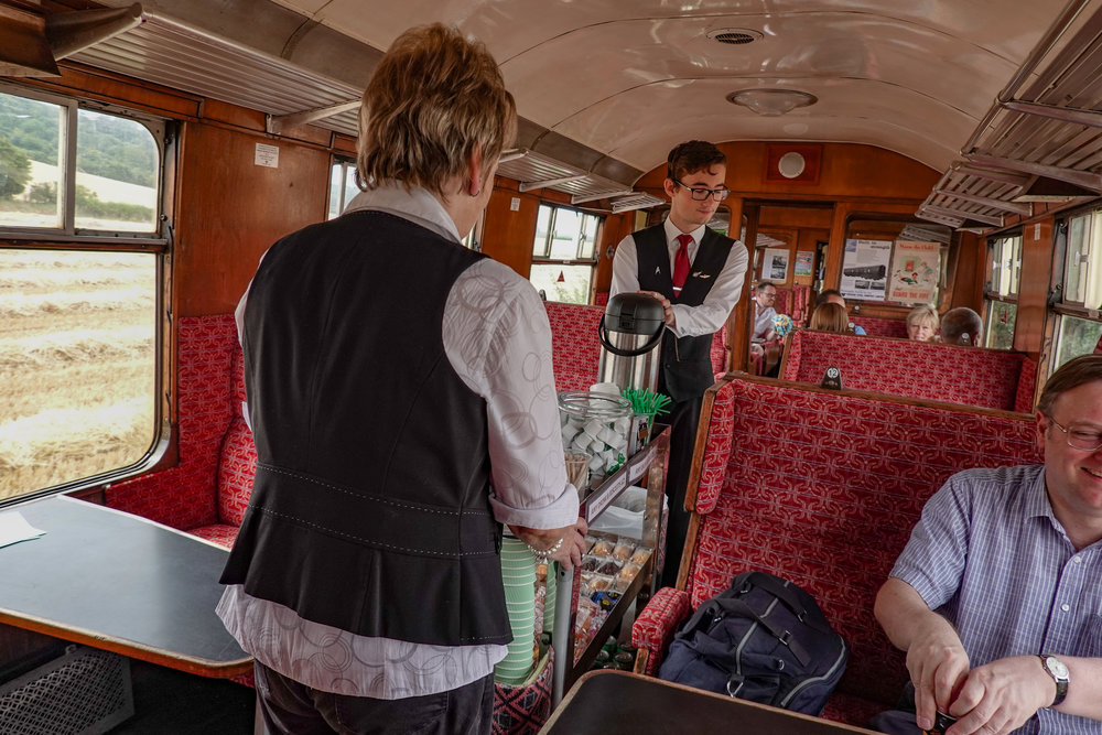 Service with a smile from a pair of courteous volunteer buffet buffs. The fields pass ever so slowly on the C&PRR. If they went any faster they couldn