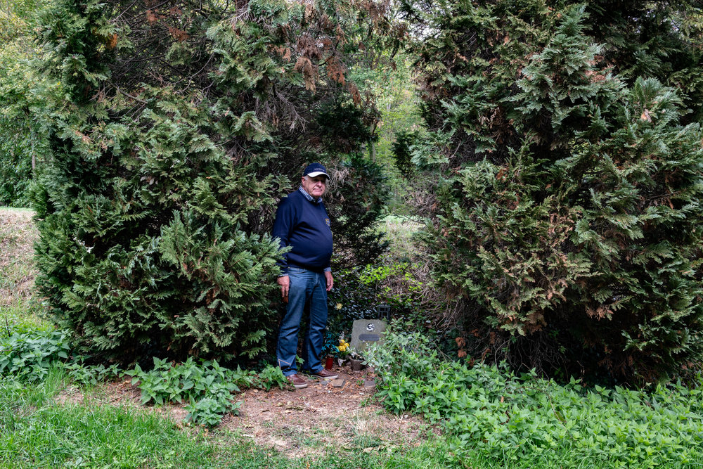 The real memorial which was reinstated by motor cycling enthusiasts following the removed of the official cross to the new site. The two conifers were planted to mark the spot, which is hard against the high river bank