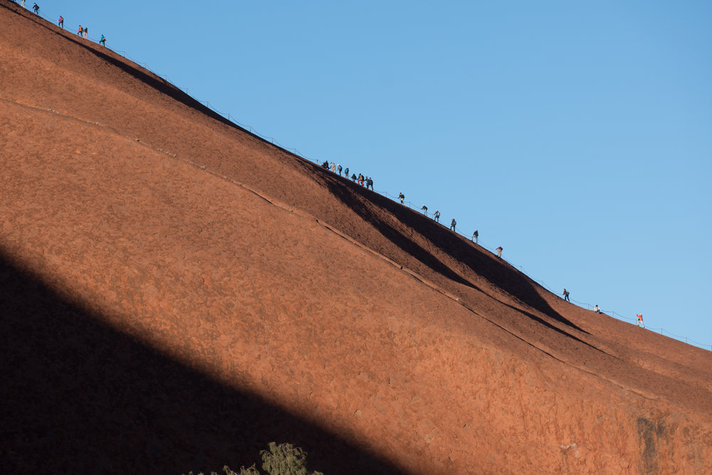 Tourists making their way up Uluru in the early morning, in spite of the requests from the indigenous owners that they respect their culture and not climb the rock. Leica CL and 55-135mm lens.