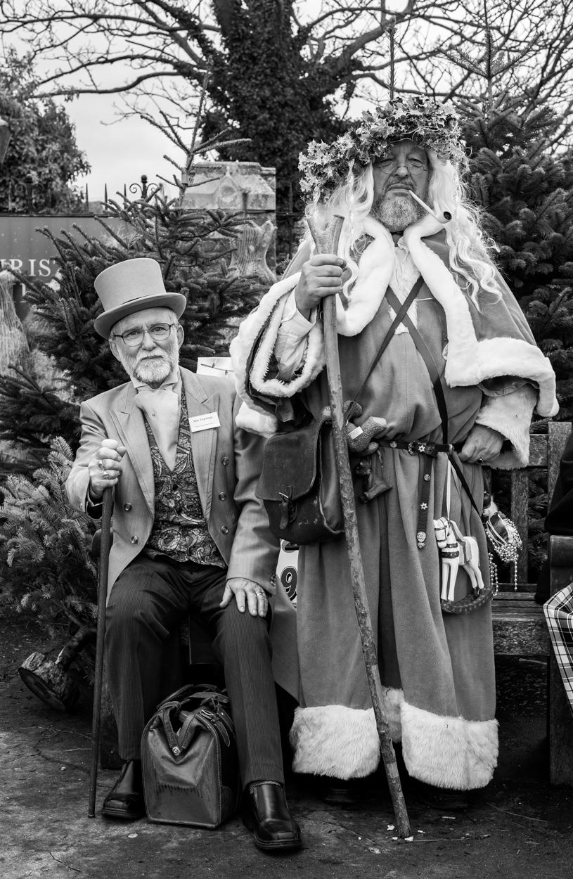 This one is easy. The gent on the left has obligingly decided to wear a name badge. He’s Mr. Topper from A Christmas Carol. Don’t know who the other chap is, though.