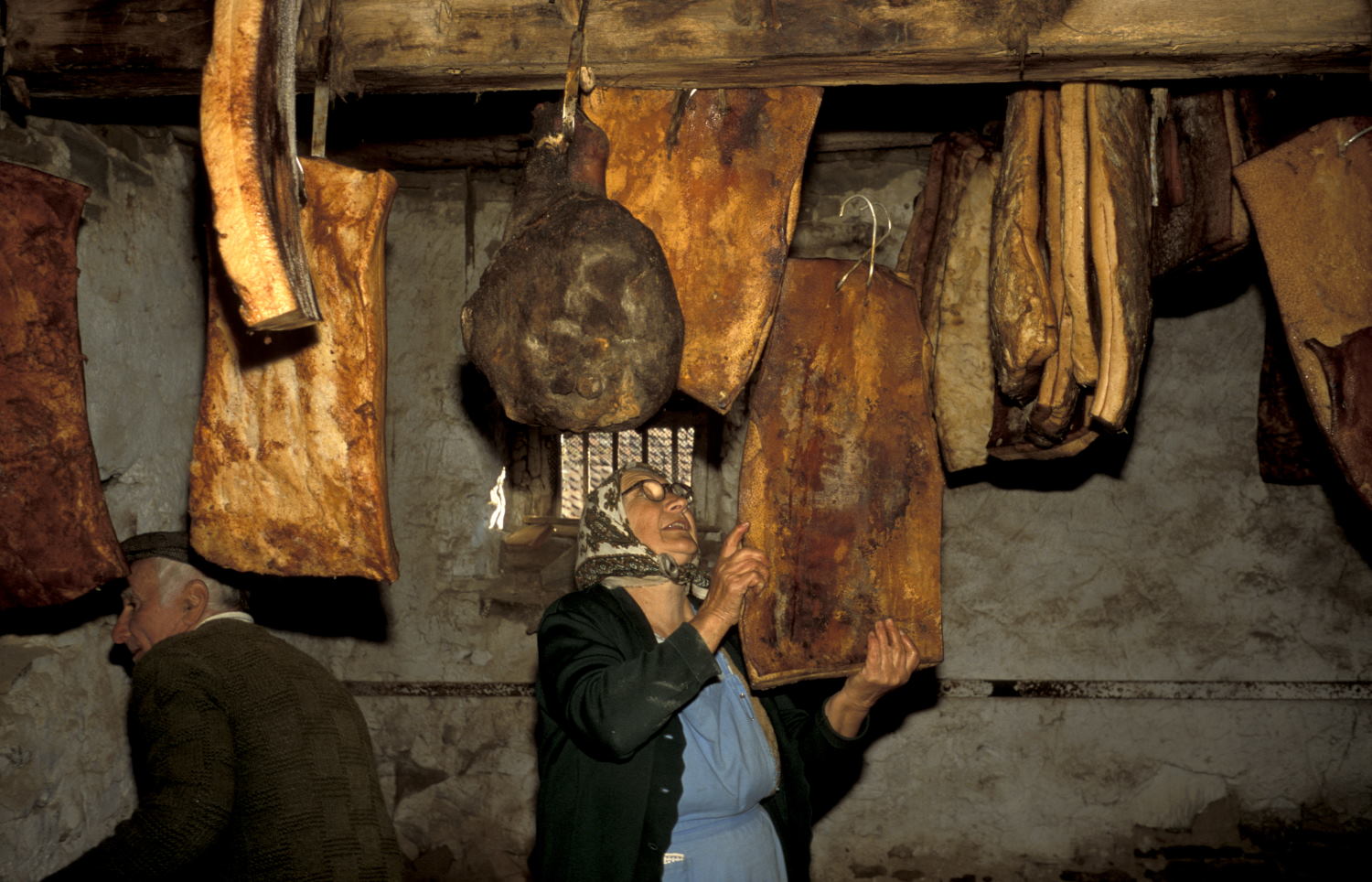 Woman collecting meat stored in fortified church Szekelyderz (Leica M6 and 35mm f/1.4 Summilux)