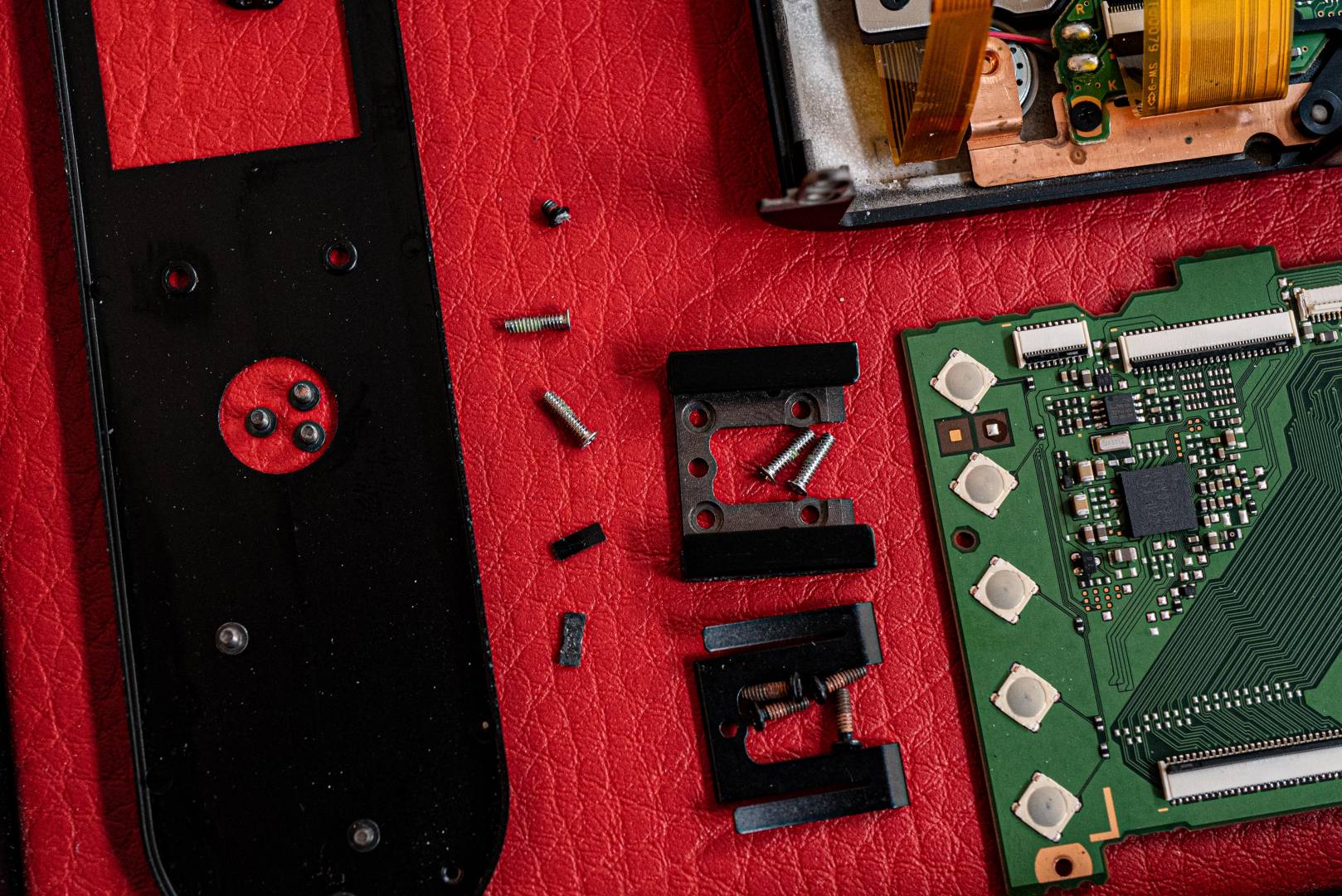 Tony screws, needing a magnifying loupe and a magnetic screwdriver to reassemle. Note the buttons to the left of the motherboard which marry up with the control buttons on the back of the camera.