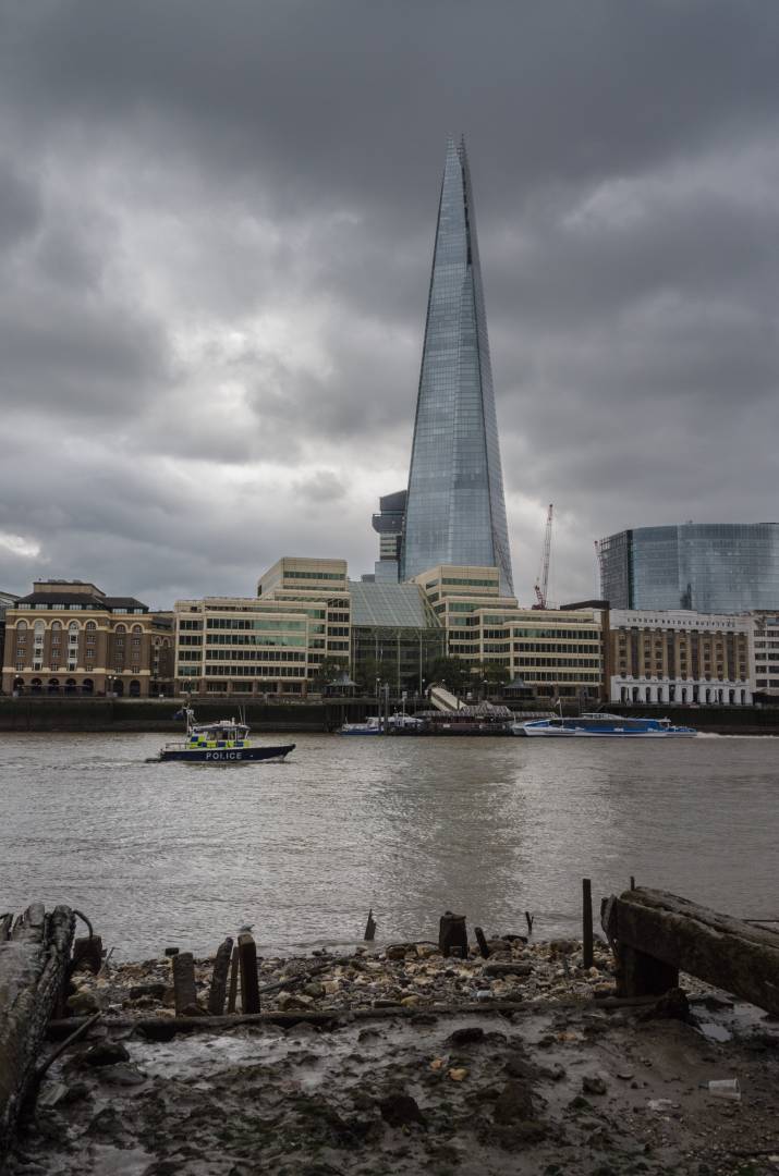 Police launch passing the old barge beds and modern Shard