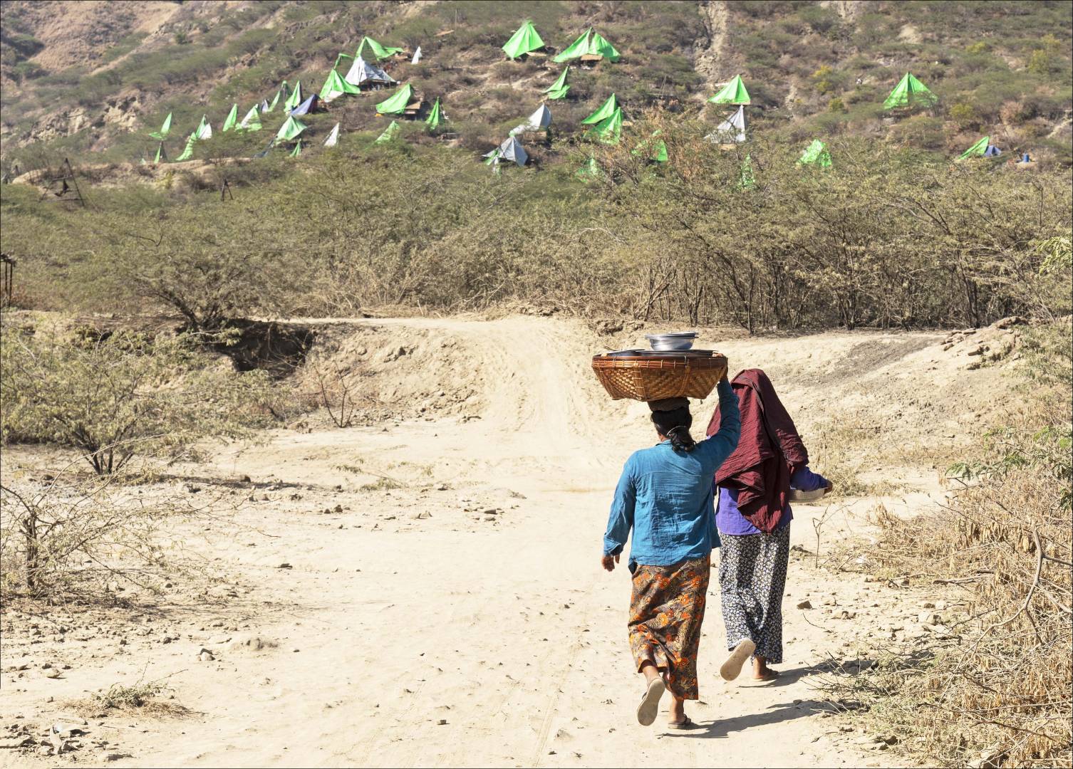Tented derricks litter the hillside, working in shifts