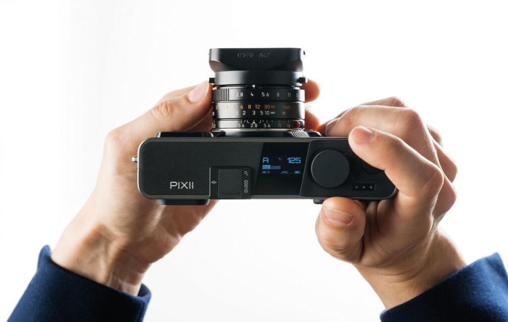 Pixii rangefinder camera in the hands of a user