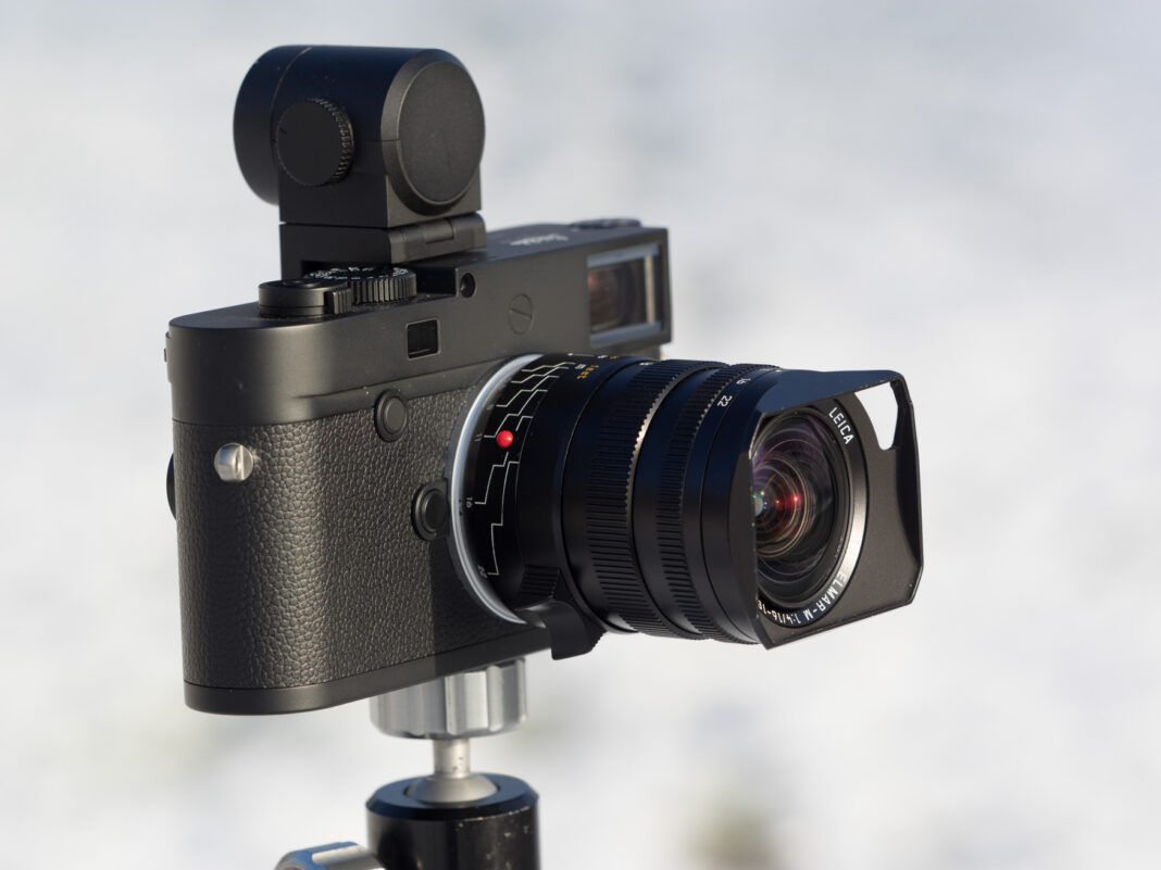 Product image shows Leica Tri-Elmar 16-18-21/4 WATE attached on a Leica M10 Monochrom camera with Visoflex electronic viewfinder.