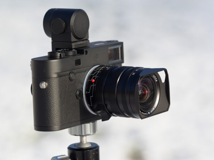 Product image shows Leica Tri-Elmar 16-18-21/4 WATE attached on a Leica M10 Monochrom camera with Visoflex electronic viewfinder.