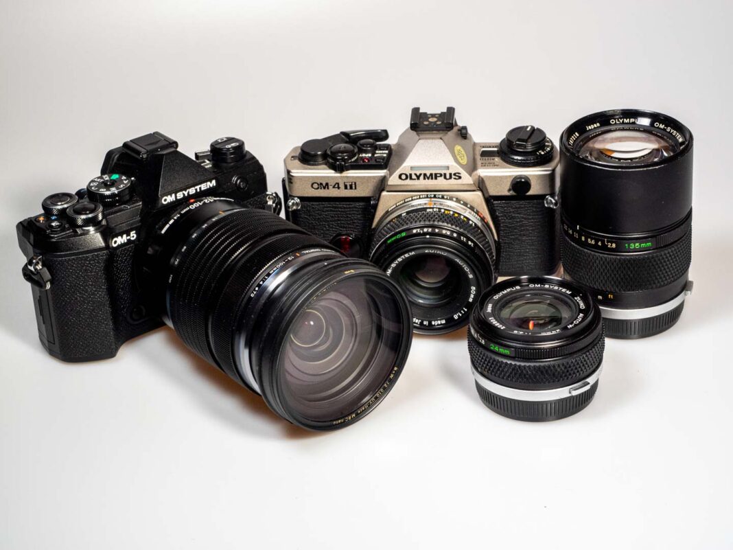 product shots shows OM System OM-5 digital camera, Olympus OM-4 Ti analogue camera and respective lenses