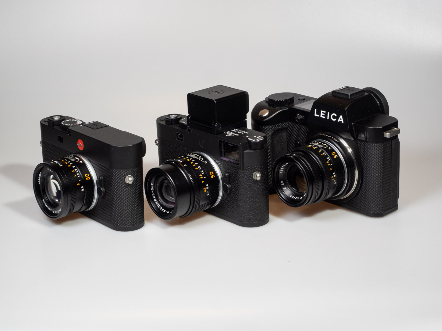 Product image shows (left to right) Leica M EV1 digital camera, Leica M11-P digital rangefinder camera with Visoflex2 electronic viewfinder, Leica SL2 digital mirrorless L-Mount camera, all with 50mm lenses mounted.