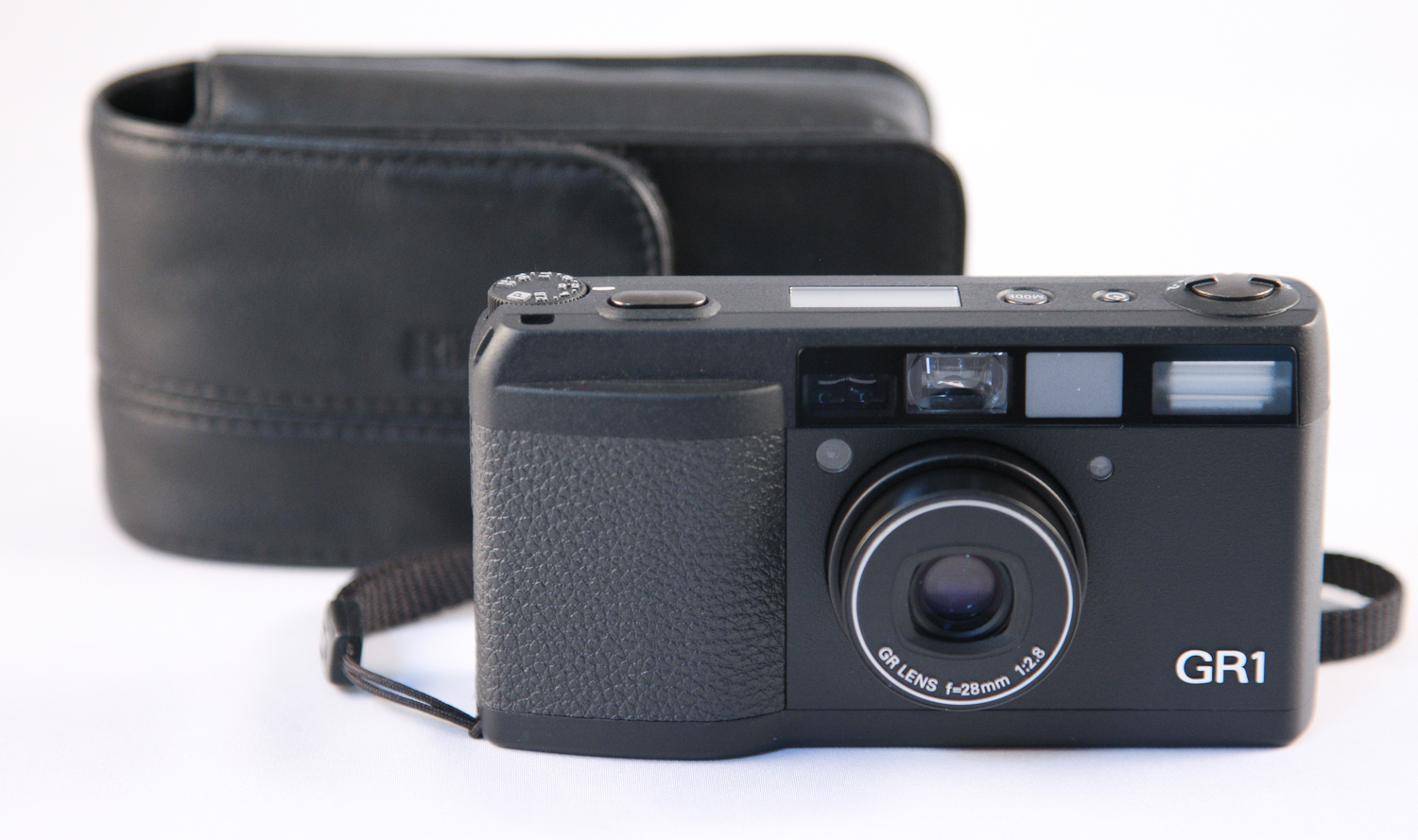 A Ricoh GR1 camera, known for its compact design and high-quality 28mm f/2.8 lens, displayed with a black leather case.