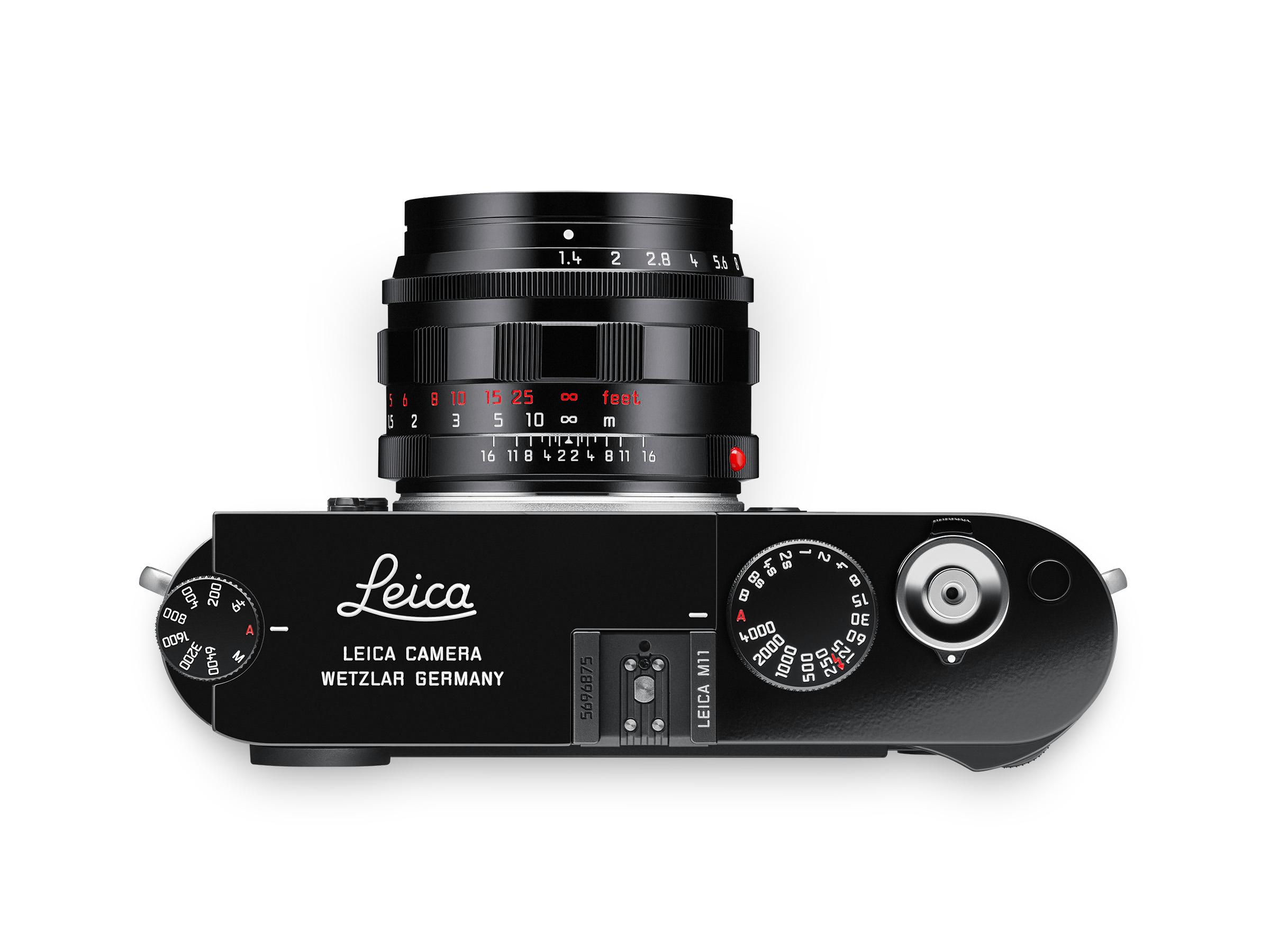 Top view of a Leica camera showing a black body and lens, with visible dials and the brand logo.