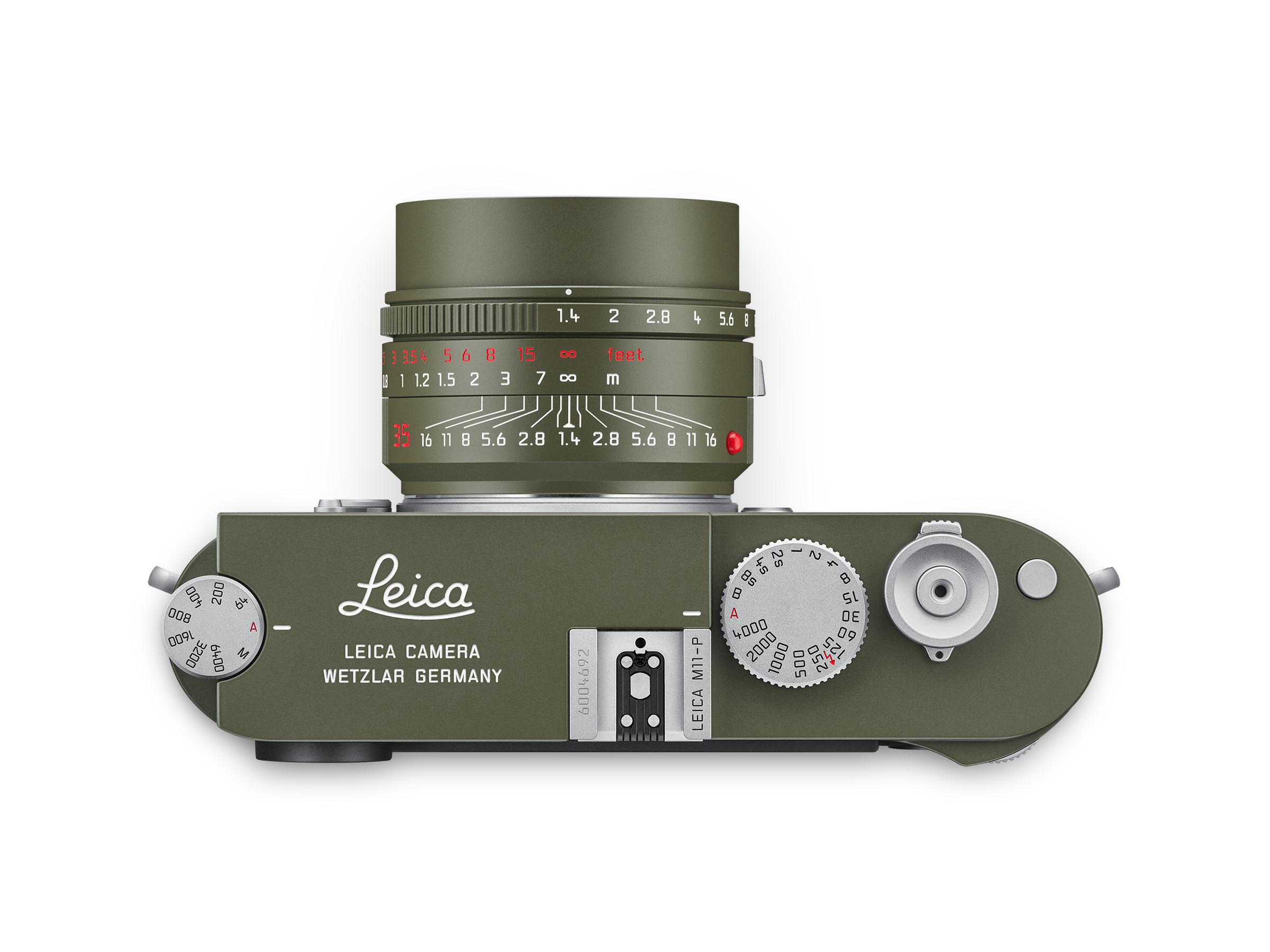 Top view of a Leica camera with a Safari-colored lens, featuring dials and settings for exposure and focus.