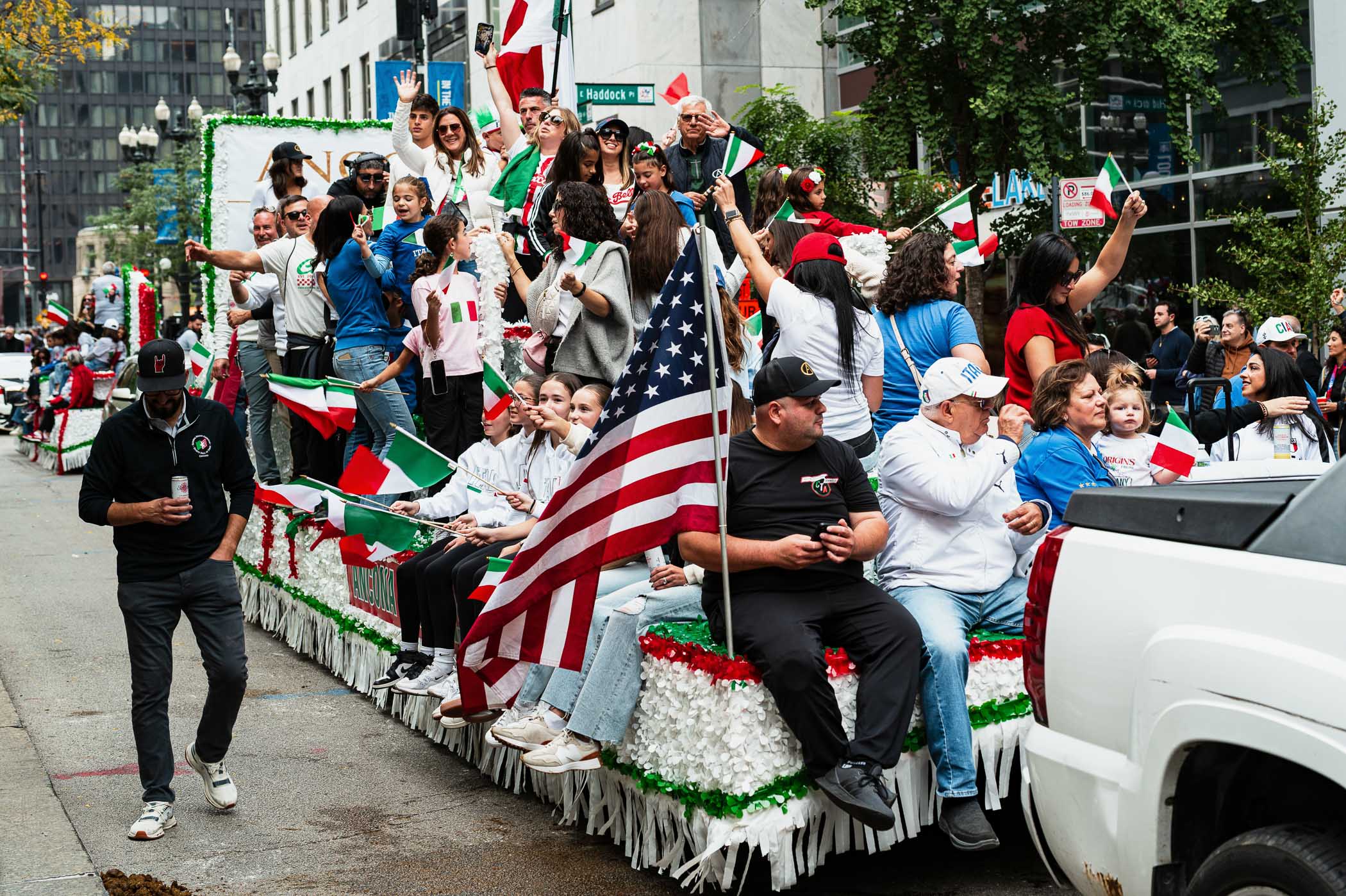 A vibrant Columbus Day parade in Chicago featuring a float decorated with Italian flags, celebrants waving and enjoying the festivities, with a mix of ethnic pride and community spirit.