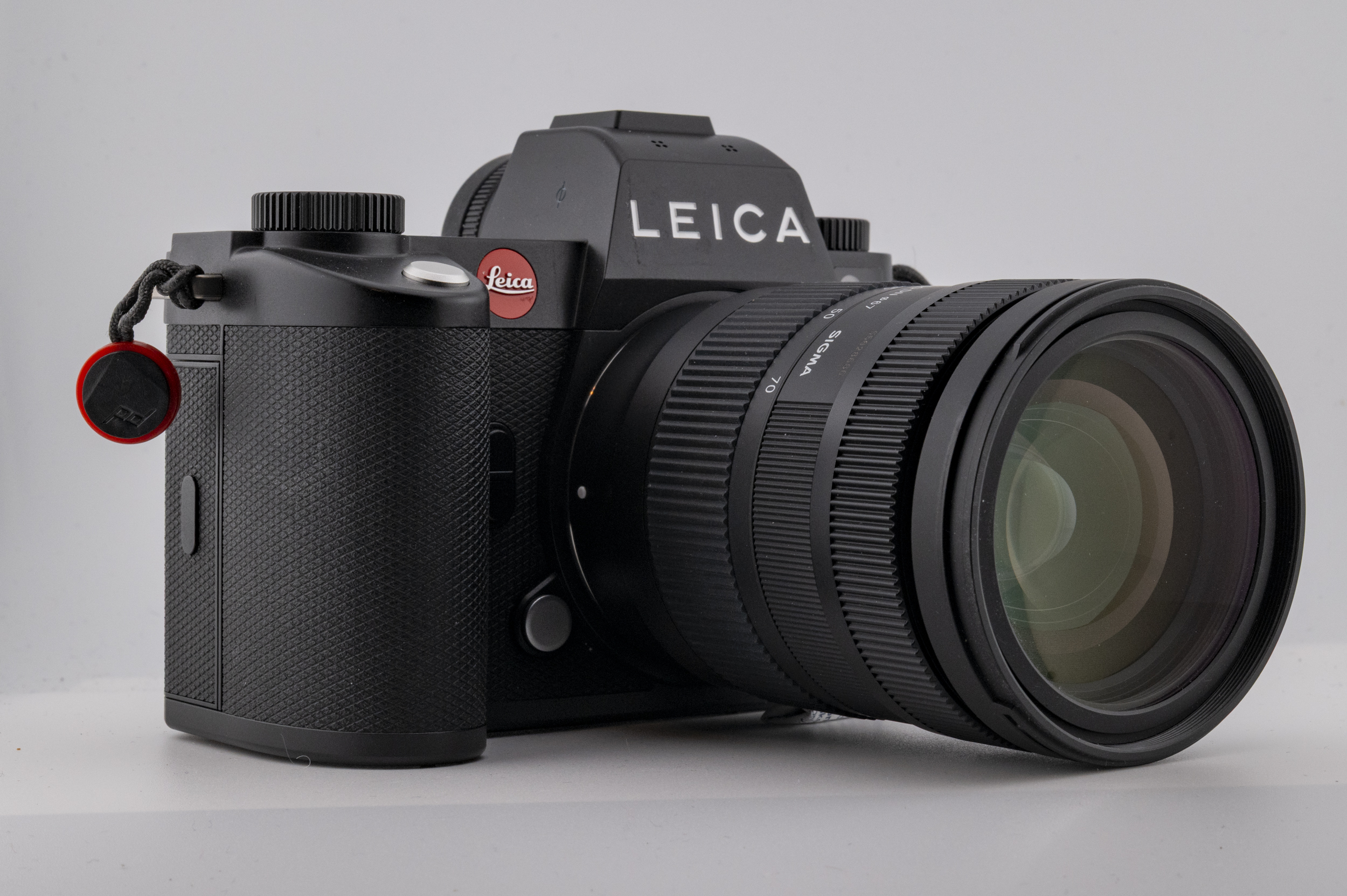 A close-up of a Leica camera equipped with a Sigma 28-70mm f/2.8 lens, showcasing its sleek design and features.
