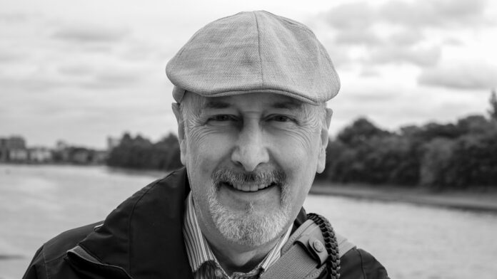 Man with cap with river in background