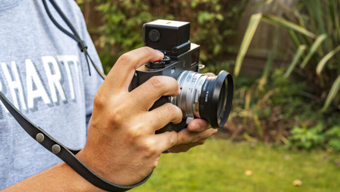 person holding Leica M11D with viewfinder and 35mm Steel Rim Summilux lens