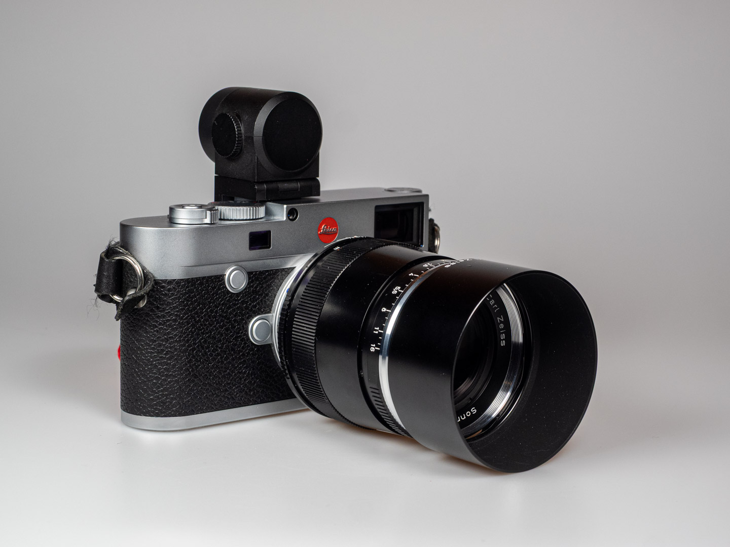 Product image shows Zeiss Sonnar 2/85 ZM telephoto M-Mount lens on Leica M10 digital rangefinder camera.