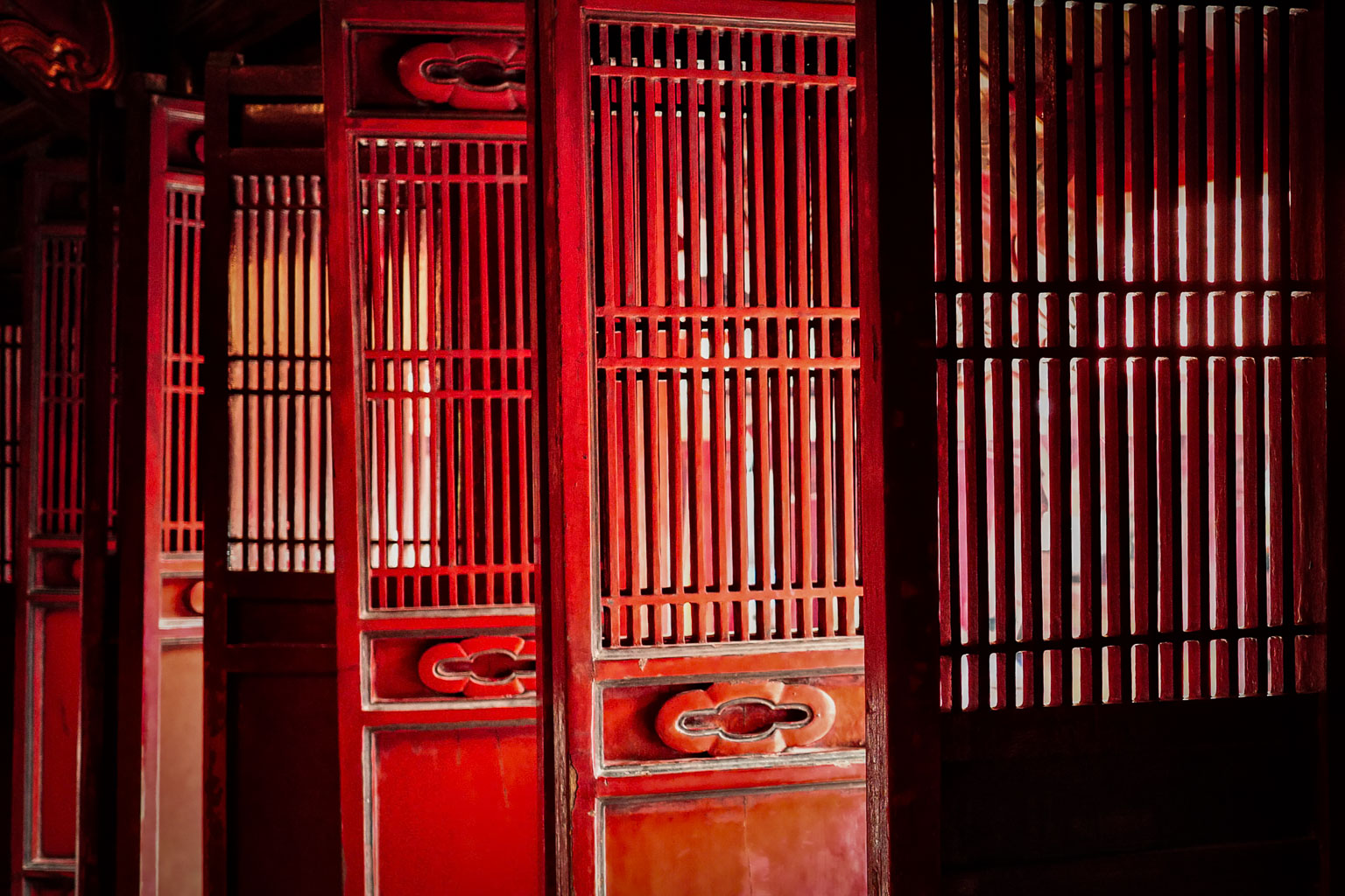 Close-up of traditional wooden red-paneled doors with slatted design, creating a warm and inviting atmosphere.
