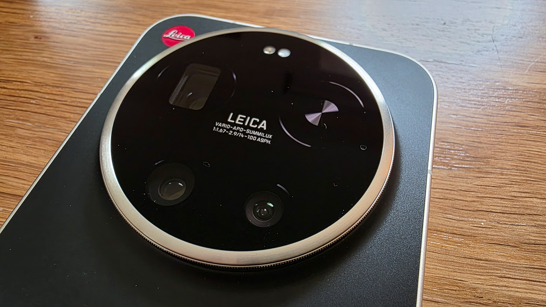 Close-up of a Leica camera lens featuring a sleek black design with silver accents and the Leica logo.