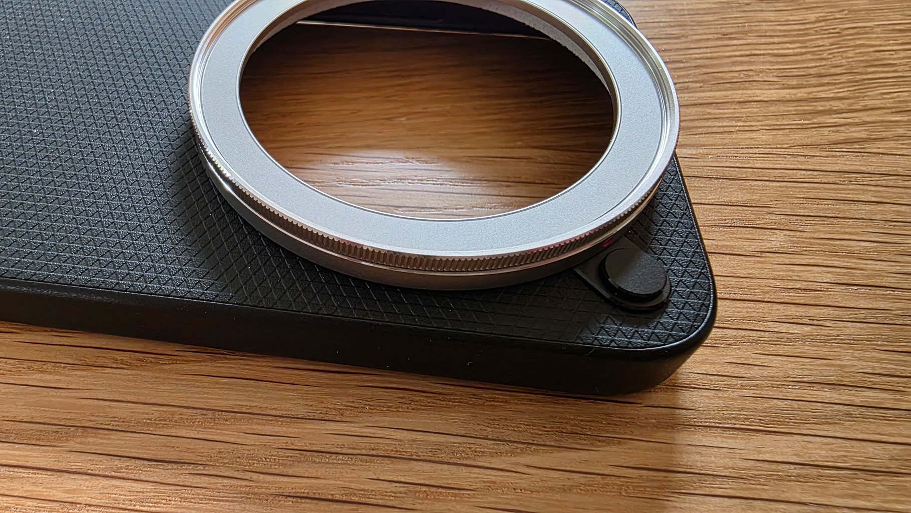 Close-up view of a camera lens mount on a textured black surface.