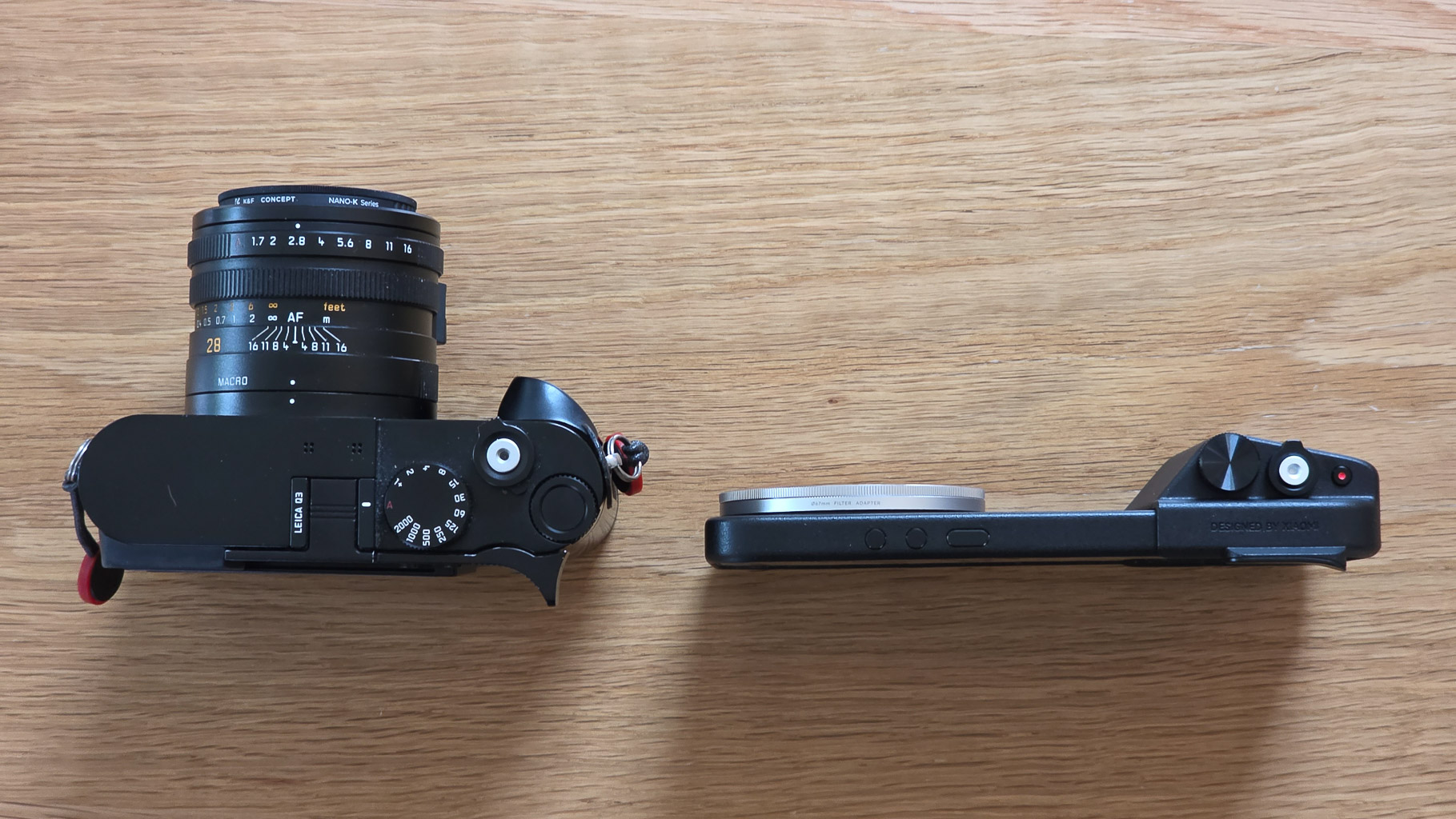 Top view of a camera showing the lens and control dials on a wooden surface.
