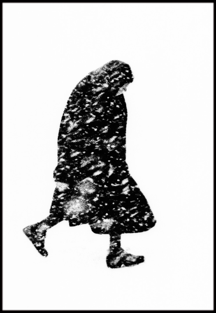 Silhouette of a person walking in a snowstorm, with swirling snowflakes creating a dramatic effect.