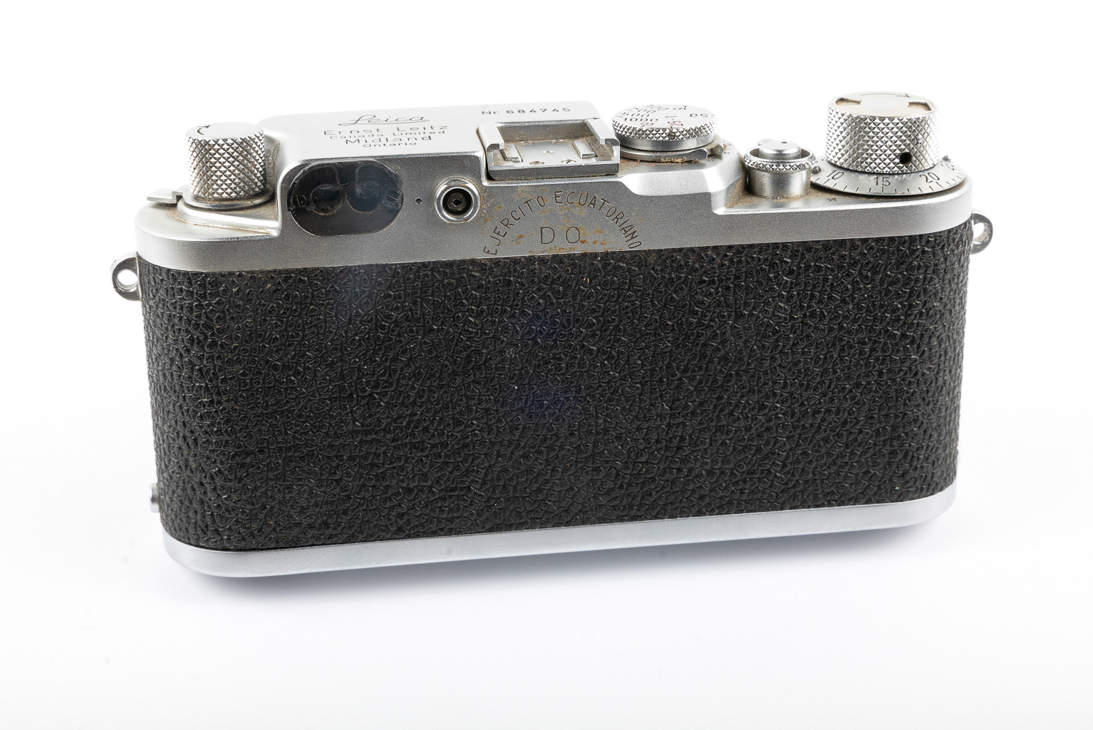 Close-up of the back view of a vintage Leica camera, featuring a textured black leather grip and several dials and controls on top.
