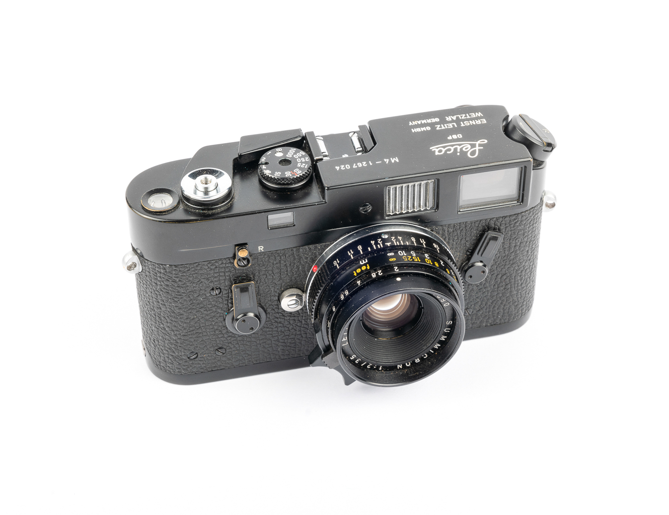 A vintage black camera with a large lens and various dials on top, showcasing its classic design and features.