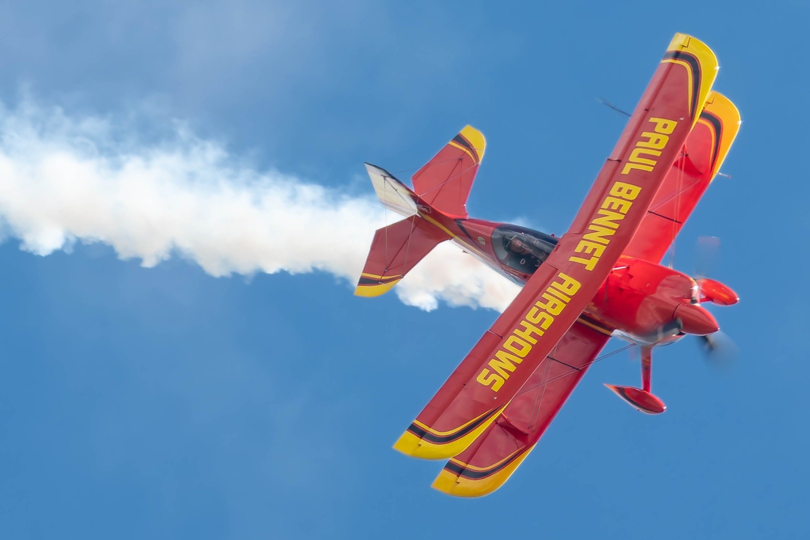 Red biplane against blue sky
