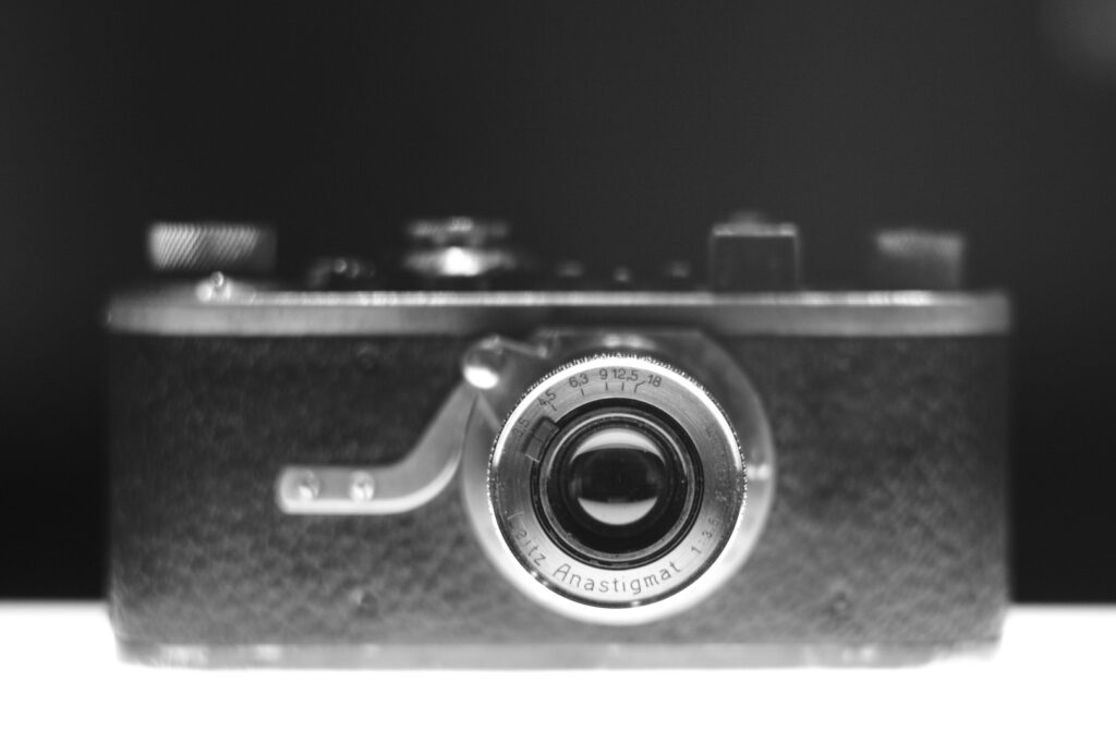 Close-up view of a vintage camera with an Anastigmat lens, set against a dark background.