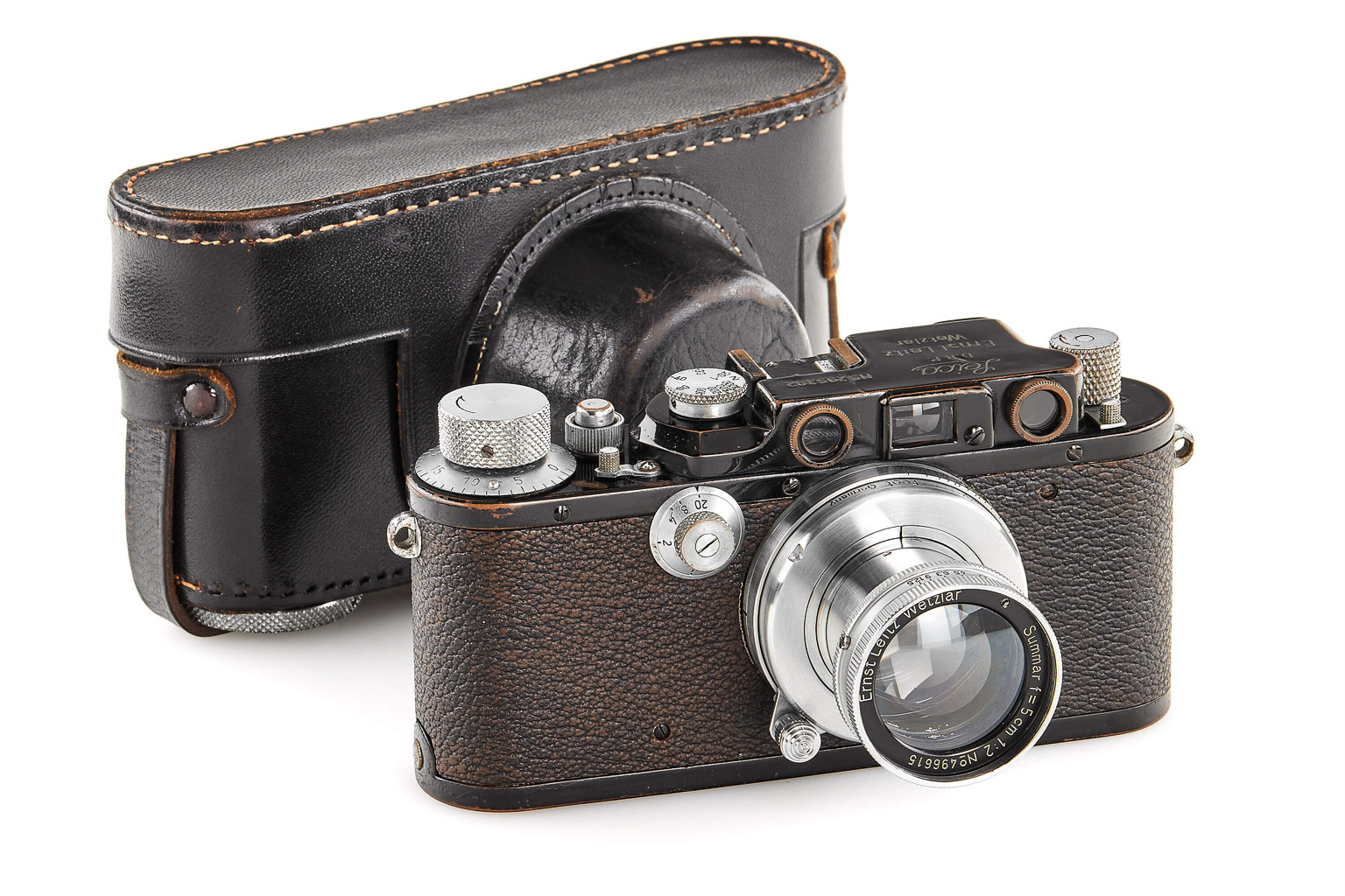 A vintage camera with a leather case, featuring a prominent lens and dials, showcasing classic design elements.