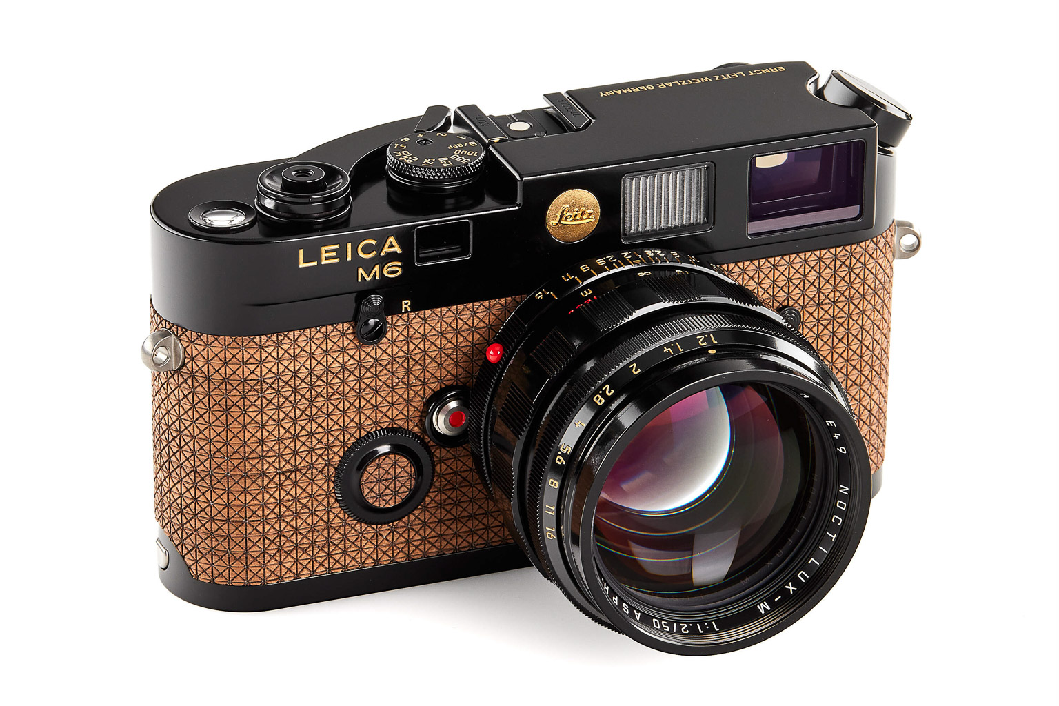 A Leica M6 camera with a distinctive textured brown leather body and a large lens, showcasing its classic design and craftsmanship.