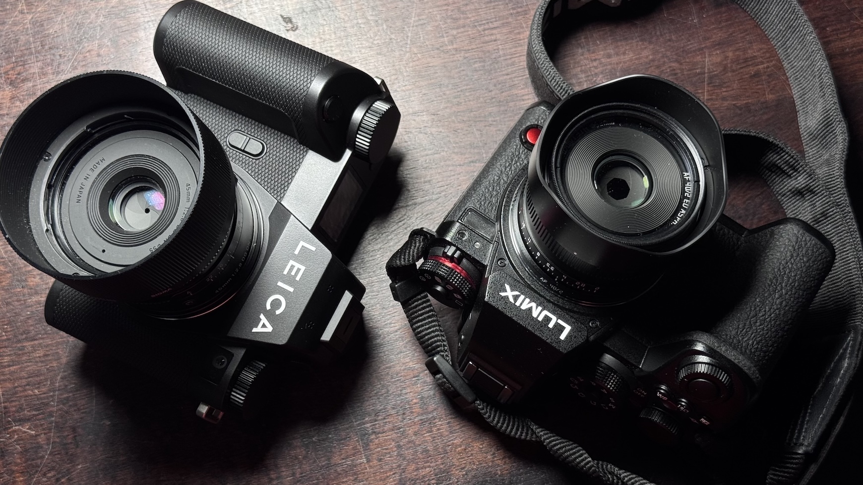 Two digital black-body cameras on a wooden surface.