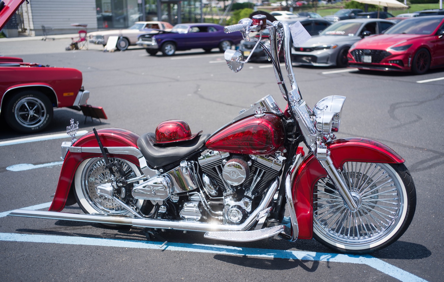 Red and chrome motorcycle on display at a car park.