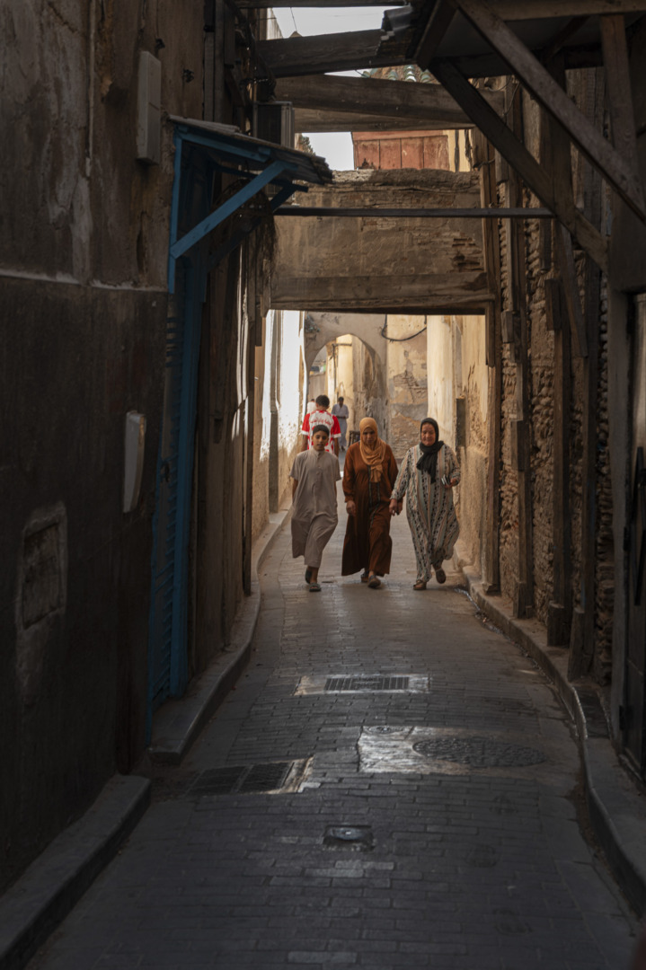 three peope walking in souk