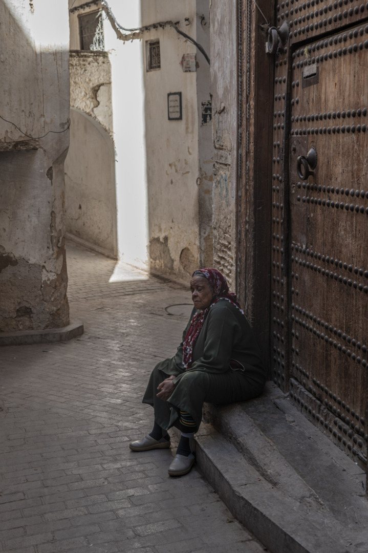 Old woman sitting on doorstep in the Medina