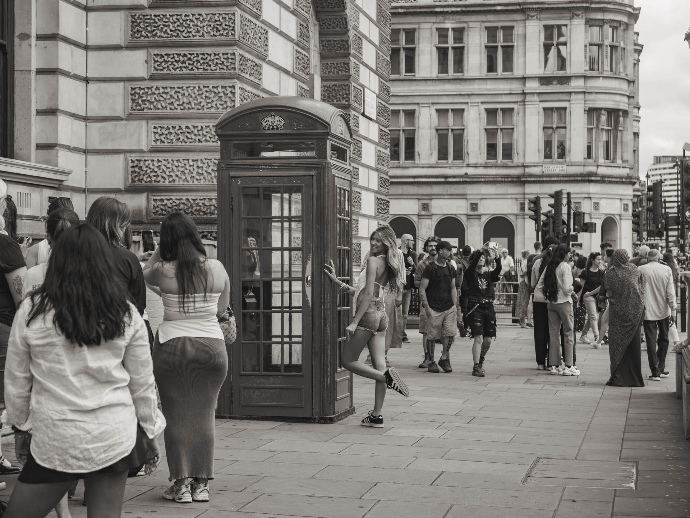 Girl posing in front of telephone kiosk